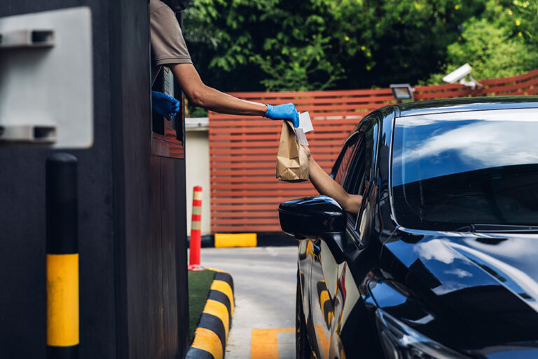 Hand man in car receiving coffee in drive thru fast food restaur